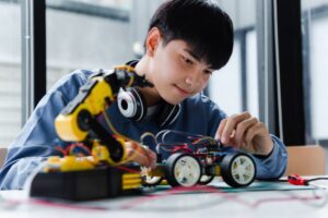 Asian male students doing robot project in science classroom