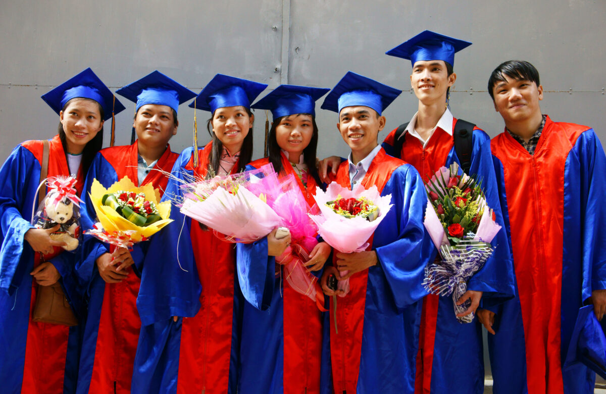 Vietnamese students wearing graduation uniform taking a picture together